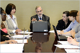 Executive Team Sitting at Conference Table During a Meeting